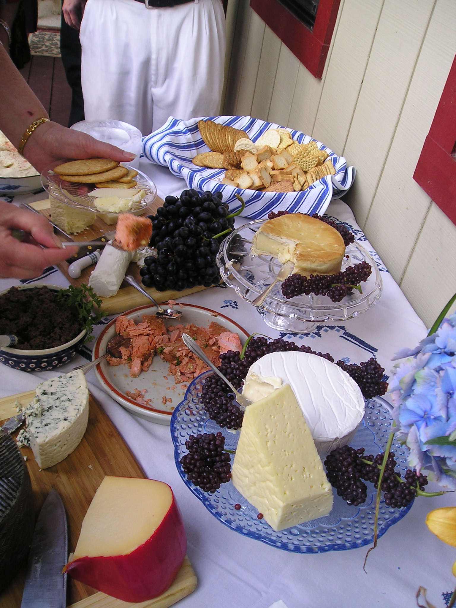 Guests serving themselves at a cheese and charcuterie table