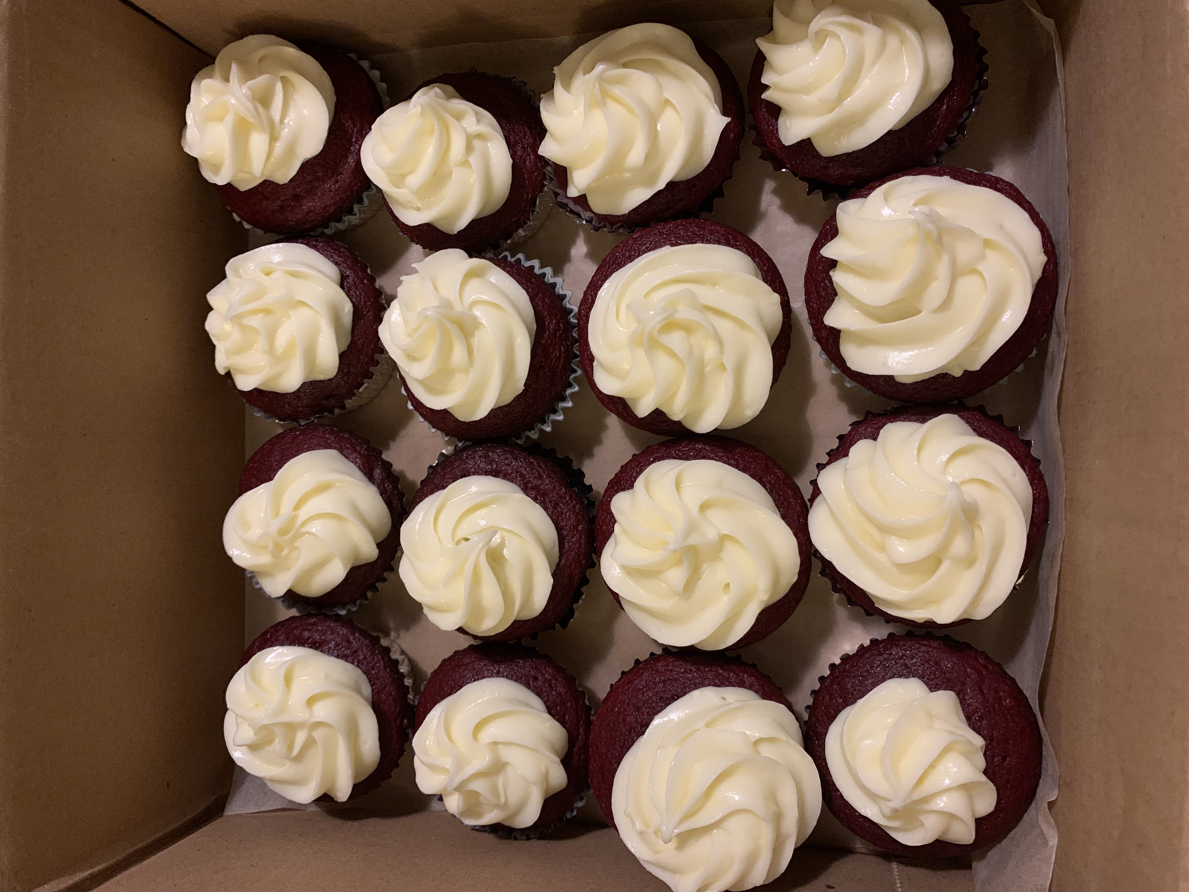 Box of mini red velvet cupcakes with cream cheese frosting