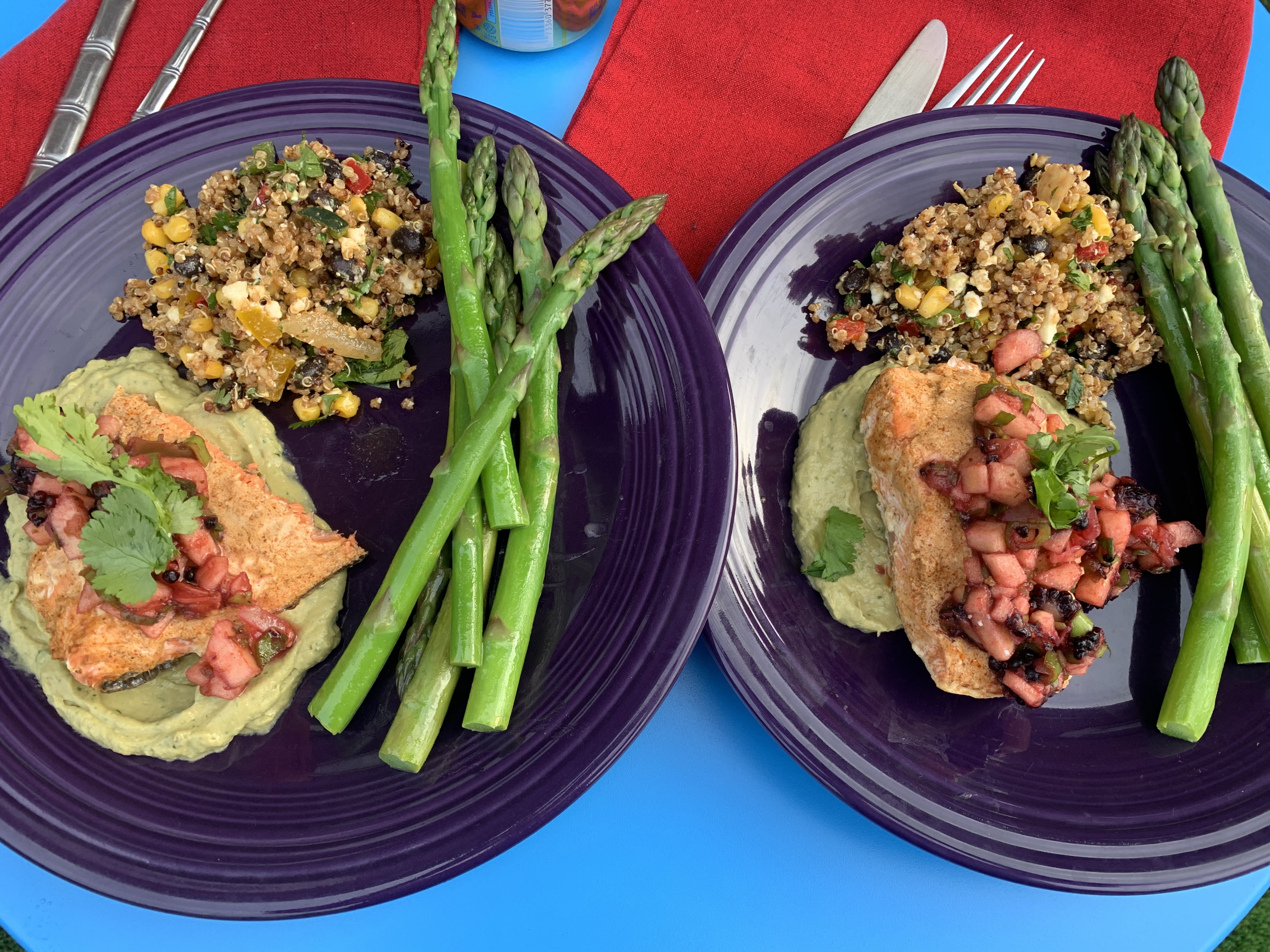 Plated dinner with salmon, avocado crema, quinoa salad, and asparagus
